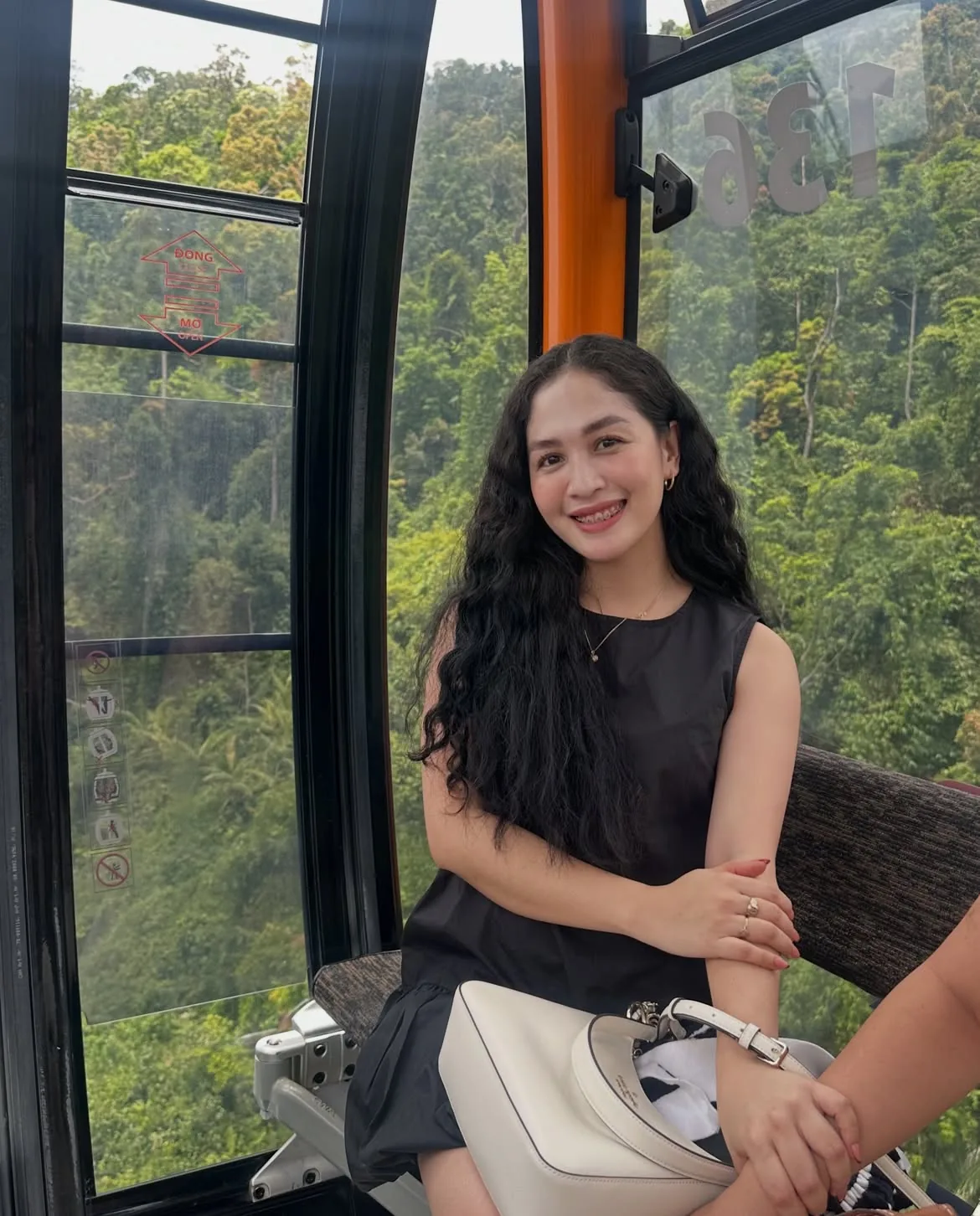 Đi Bà Nà Hills Lúc Mấy Giờ Để Khỏi Chờ Cáp Treo? 2 Du khách ngồi trong cabin cáp treo Bà Nà Hills vào buổi sáng