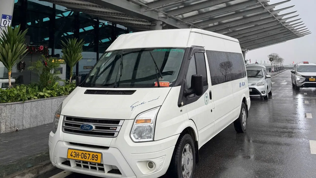 Xe 16 chỗ đón khách tại sân bay Đà Nẵng - Minh Vũ Travel Xe 16 chỗ Minh Vũ Travel đón khách tại sân bay Đà Nẵng trong trời mưa